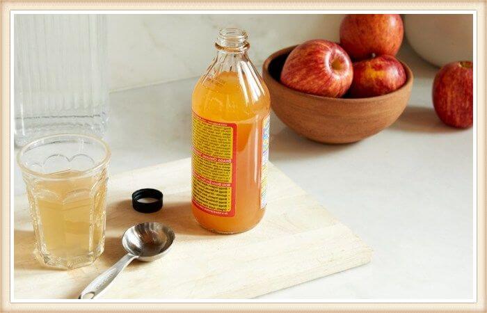 frasco de vinagre de manzana sobre tabla de cocina