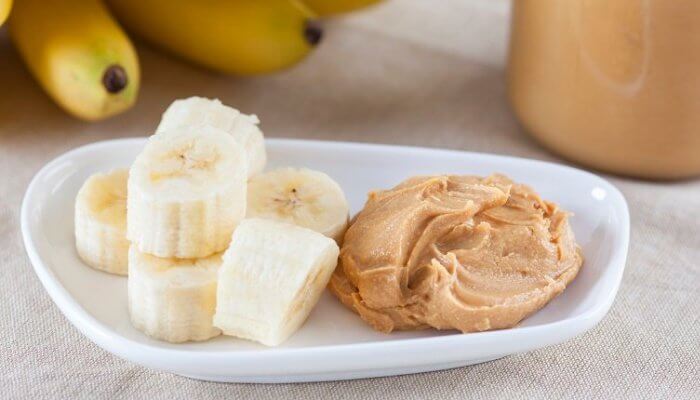 banana cortada y mantequilla de mani en plato