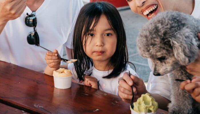 familia tomando helado junto a su perro