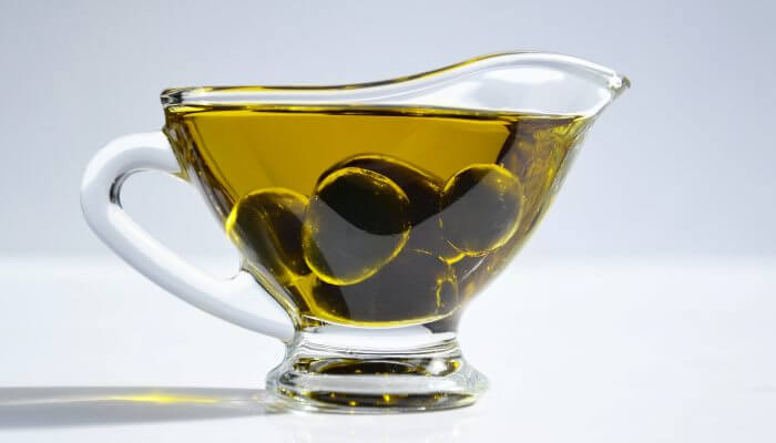 tazon de aceite de oliva con aceitunas dentro